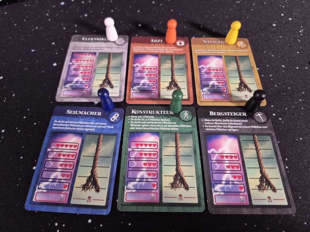 Sechs Karten mit Text und Symbolen, sechs farblich passende Pöppel.