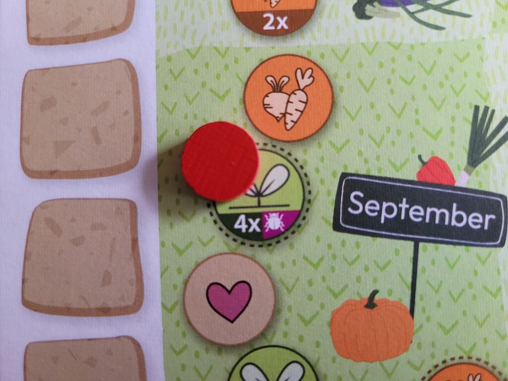 Ein Marker liegt auf einem Feld des Spielplans von "Homefarming".