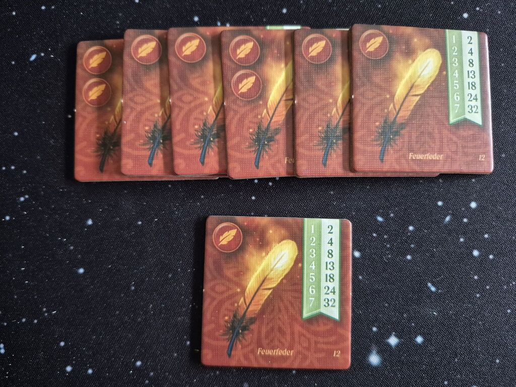 Plättchen mit einer golden strahlenden Feder und Zahlen.