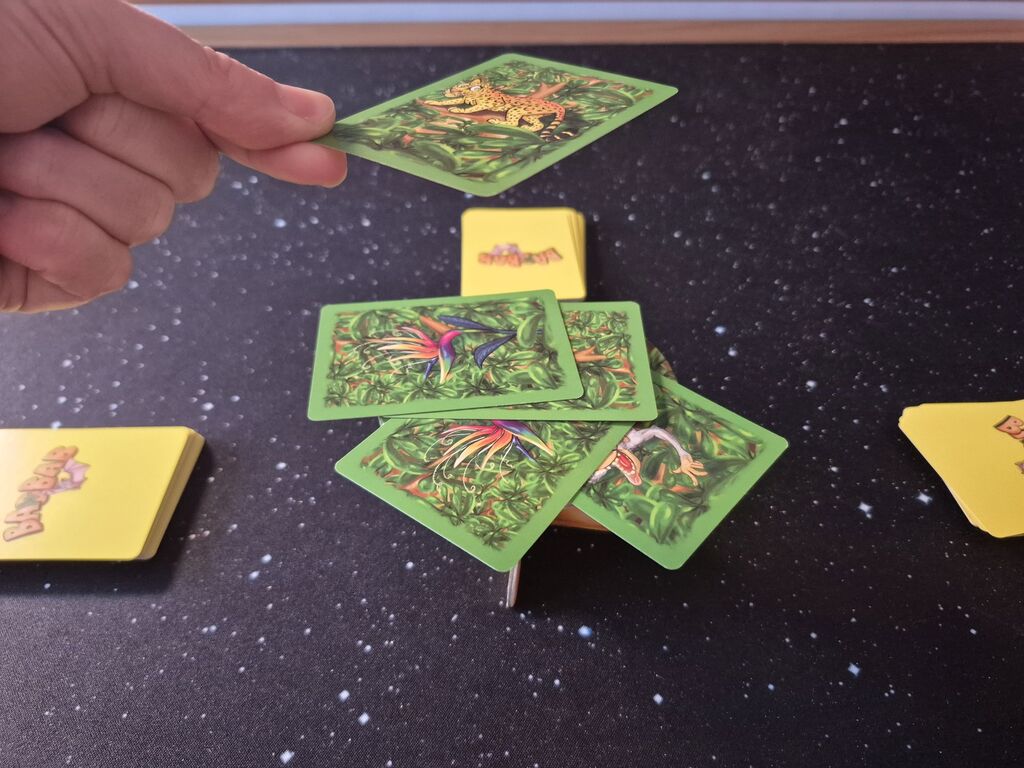 Hand hält Karte über Kartenstapel.