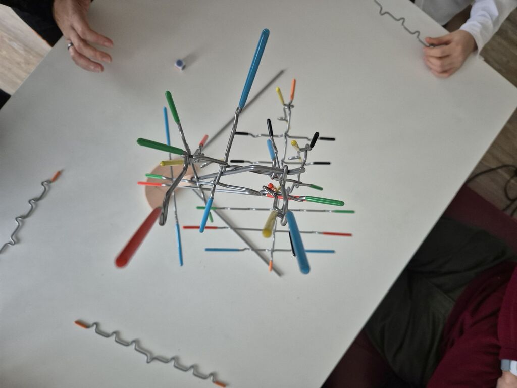 Spielmaterial im Spielverlauf mit noch mehr Metallstäben.