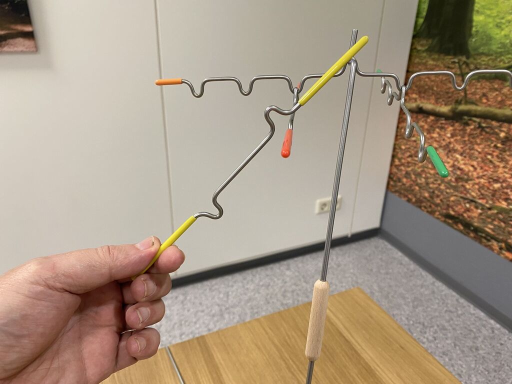 Eine Hand hält einen Stab über weitere Stäbe von "Suspend".