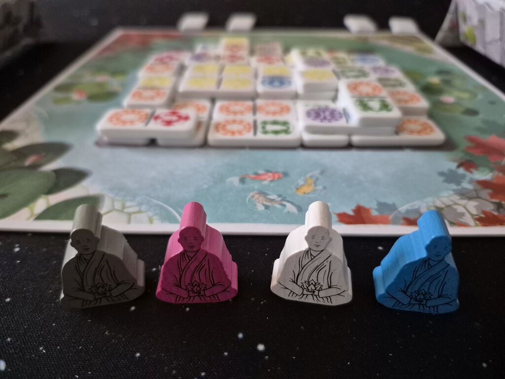 Spielfiguren mit Spielmaterial im Hintergrund.