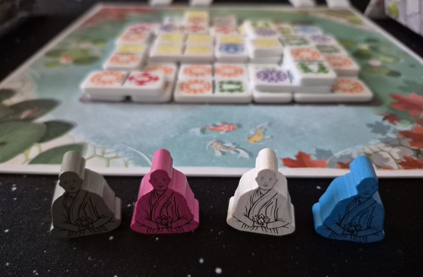 Spielfiguren mit Spielmaterial im Hintergrund.