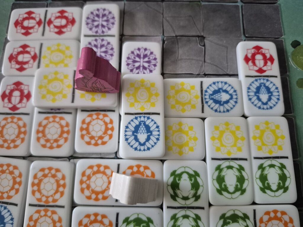 Spielplanausschnitt mit Spielfiguren und Spielsteinen.