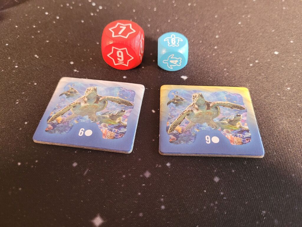 Zwei Würfel und zwei Wettkampfplättchen.