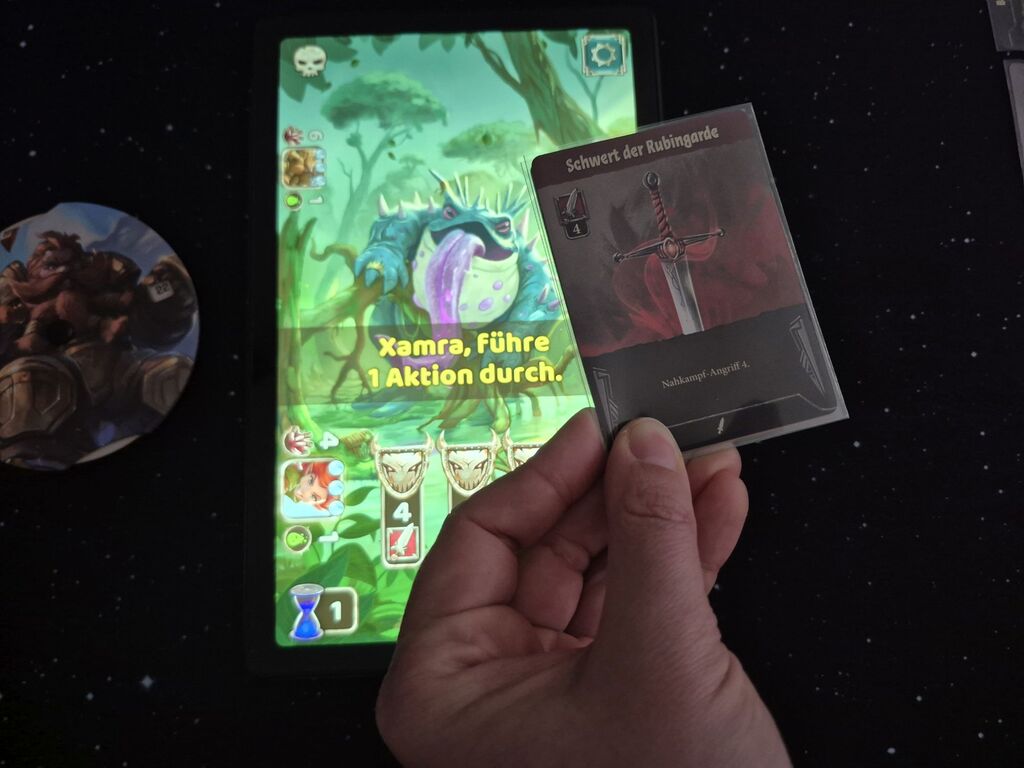 Hand hält Karte über Tablet.