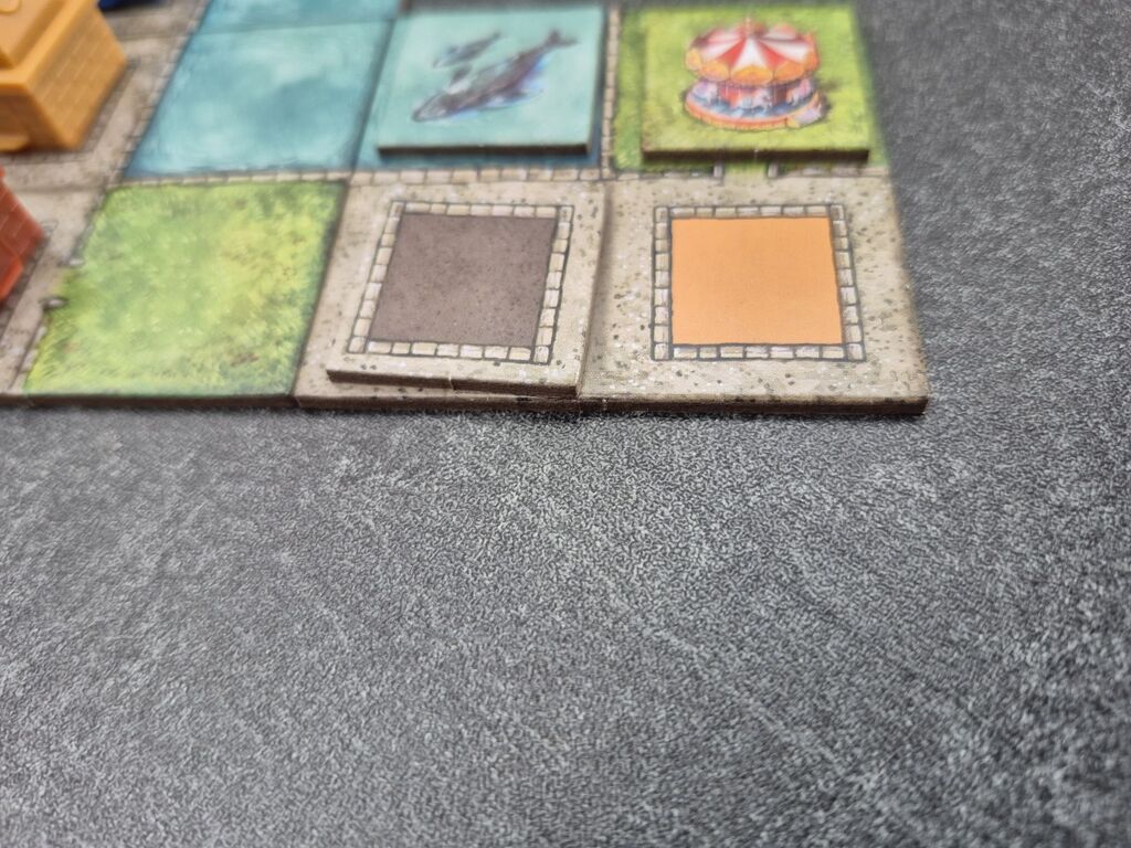 Das Plättchen liegt auf dem Stadtplan-Teil.