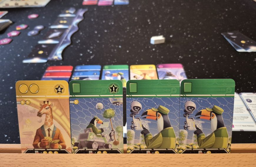 Karten, im Hintergrund weiteres Spielmaterial.