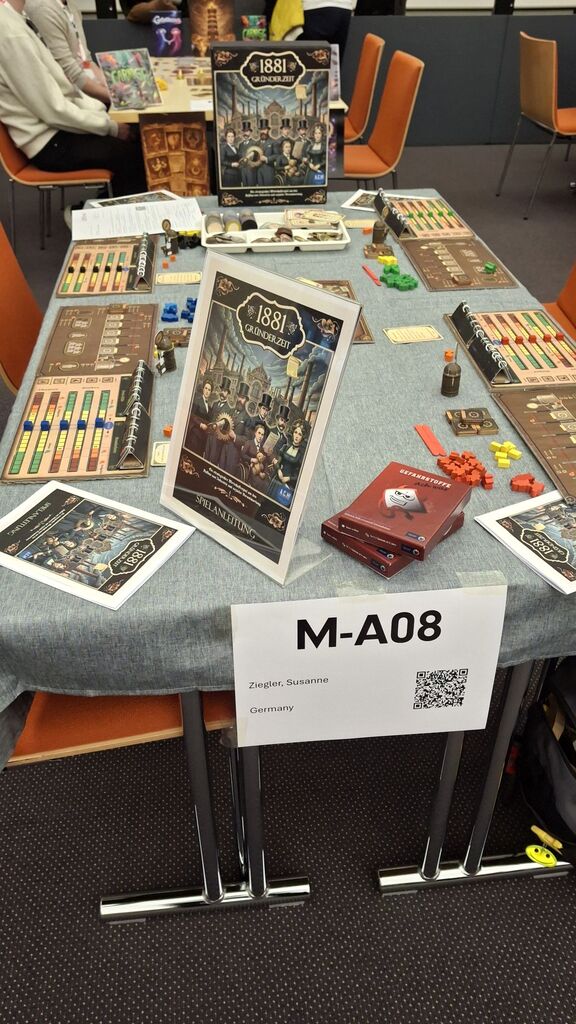Ein Tisch als Messestand mit dem Spielmaterial von "Gründerzeit 1881".
