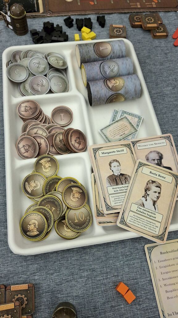 Münzen und Karten und weiteres Spielmaterial.