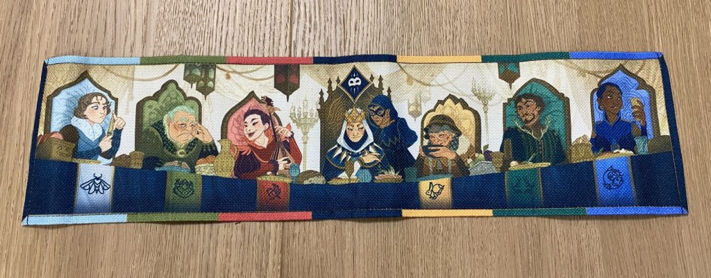 Spielmatte mit am Tisch sitzenden Menschen bei Hof.