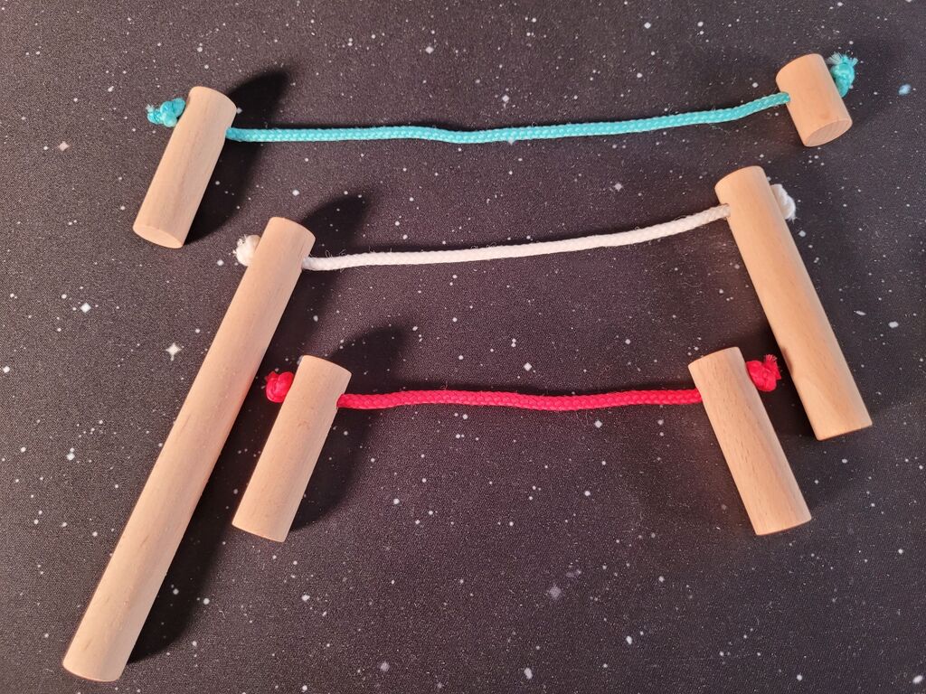 Je zwei Holzsäulen, die mit einer dicken Schnur verbunden sind.