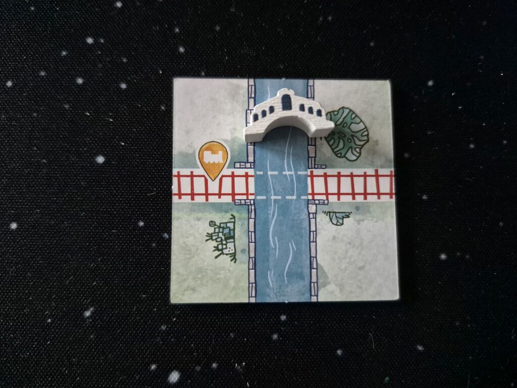 Plättchen mit kleiner Holzbrücke.