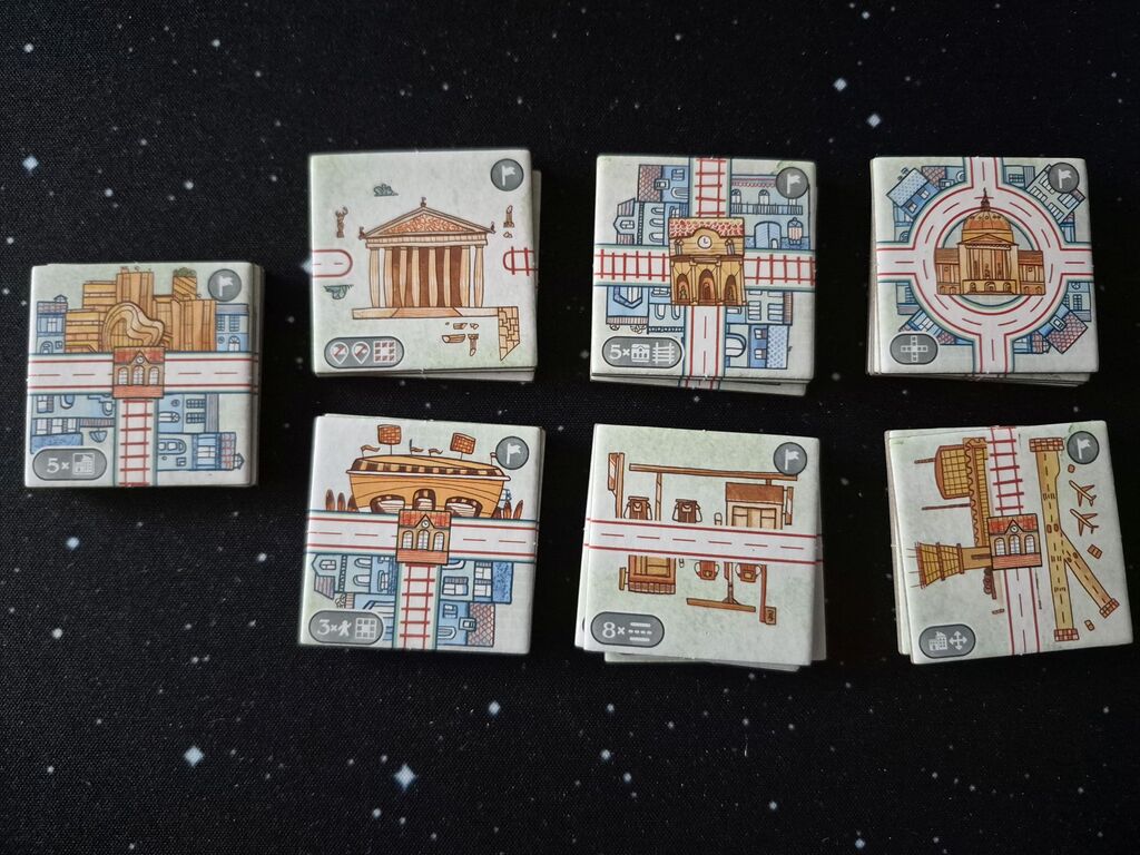 Sieben Stapel quadratischer Plättchen mit Illustration und Symbolen.