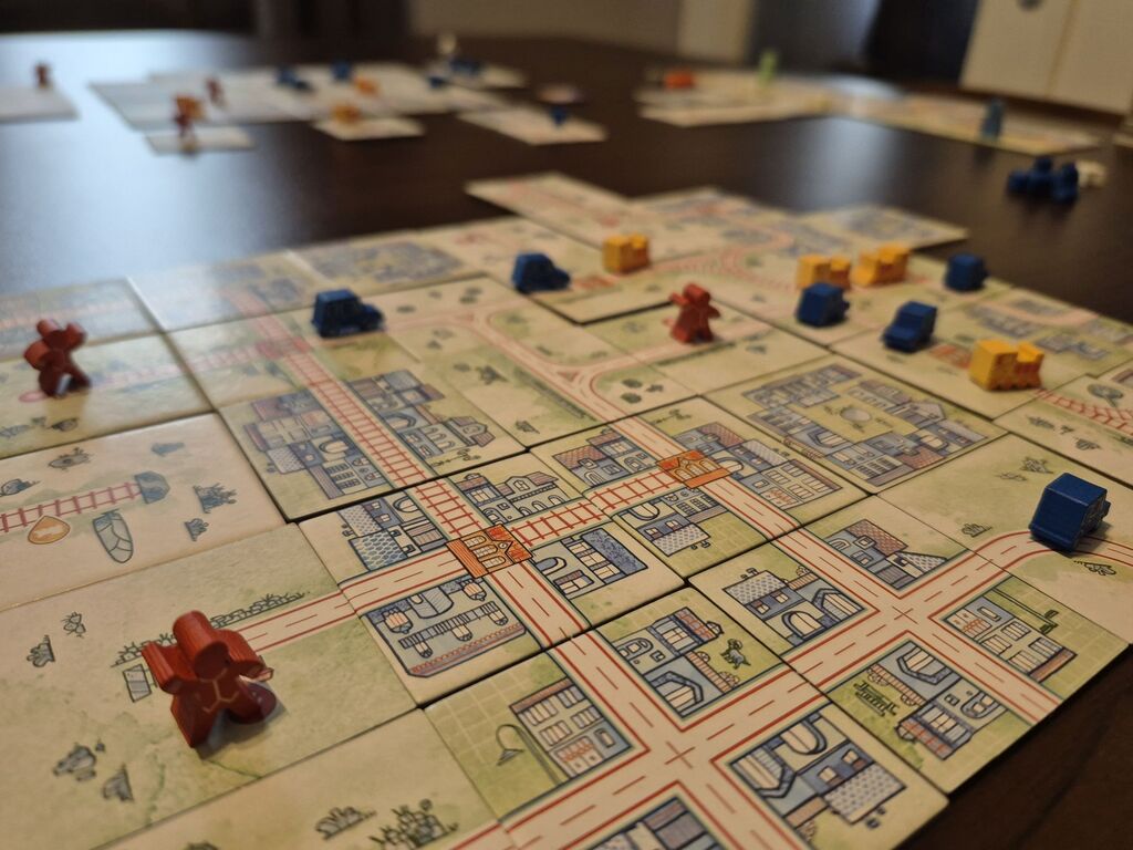 Spielmaterial mit Spielfiguren und Plättchen von "Railroad Tiles".