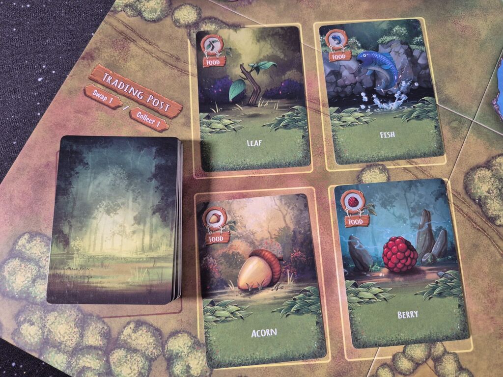 Vier aufgedeckte Karten und ein verdeckter Stapel auf dem Spielplan von "Survivel of the Fattest".