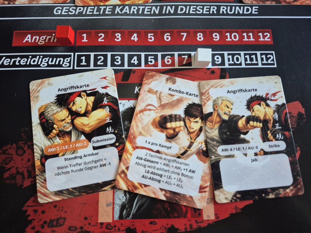 Karten auf Spielplan unter Skalen für Angriff und Verteidigung.