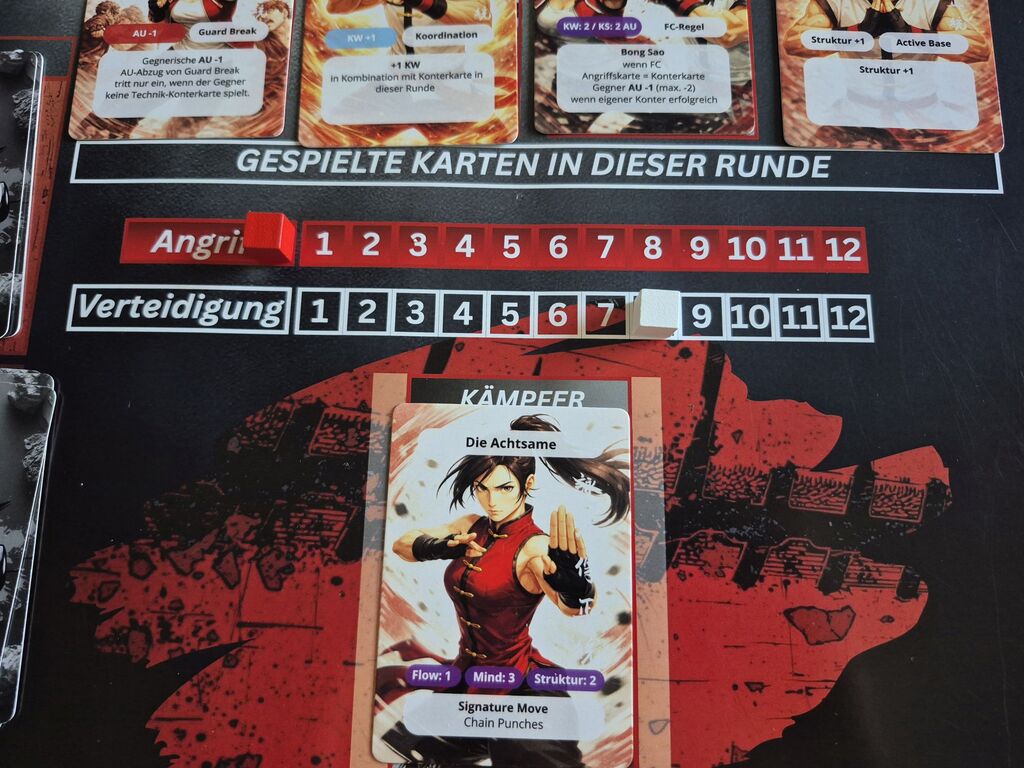 Karten mit Text auf Spielmatte mit Skala.