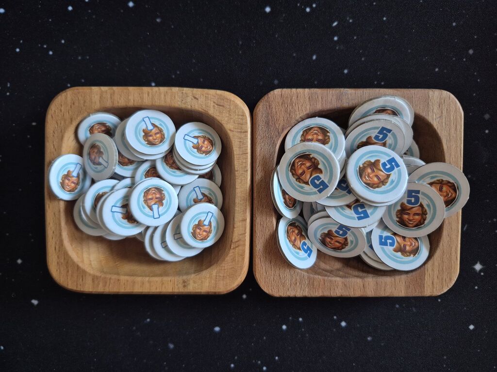 Zwei Holzschalen mit Plättchen mit einem Gesicht.