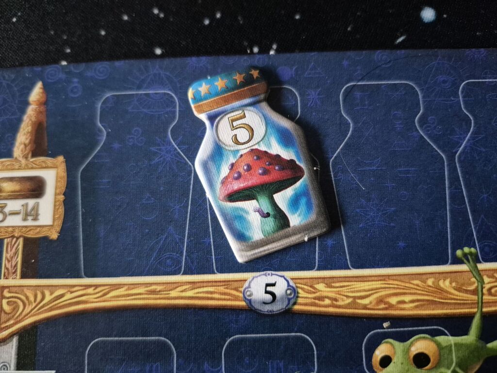Plättchen mit Zahl und Illustration auf Spielplan.