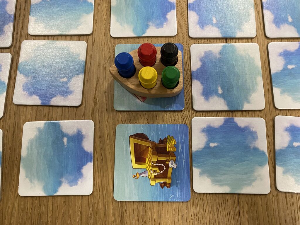 Fünf Spielfiguren in Holzboot auf Plättchenraster von "Käpt'n Memo".