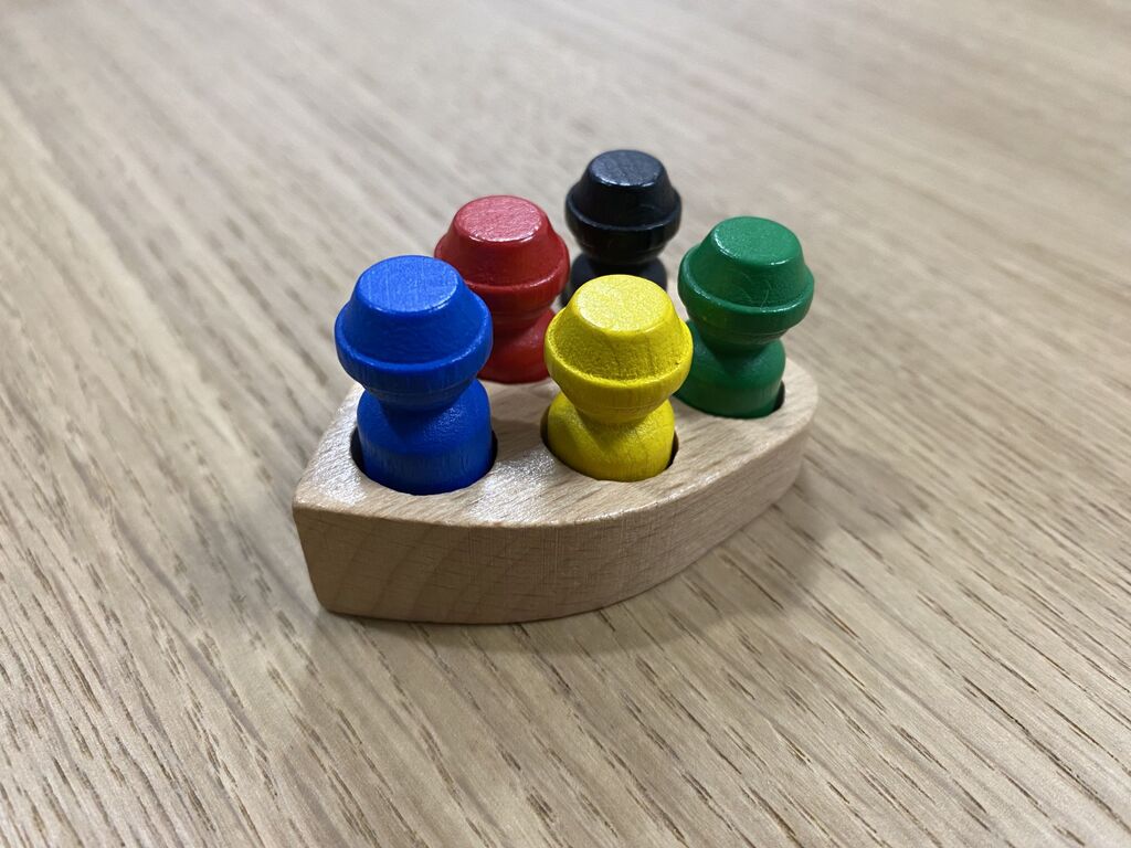 Holzboot mit fünf Spielfiguren.