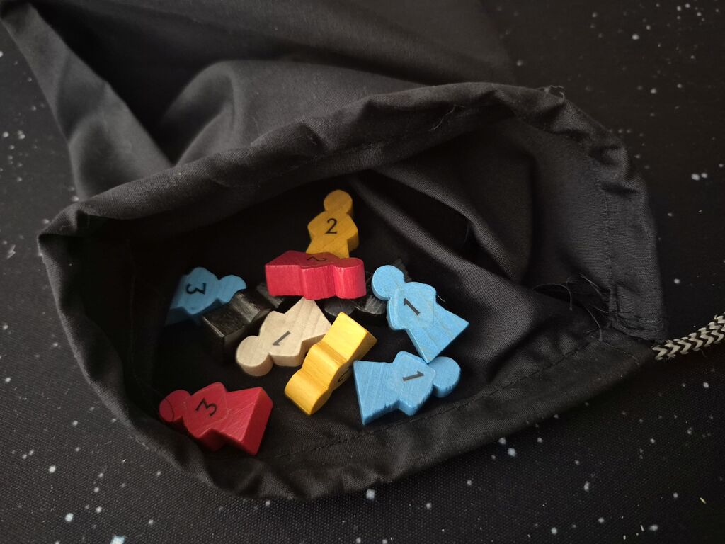 Meeple in schwarzem Beutel.