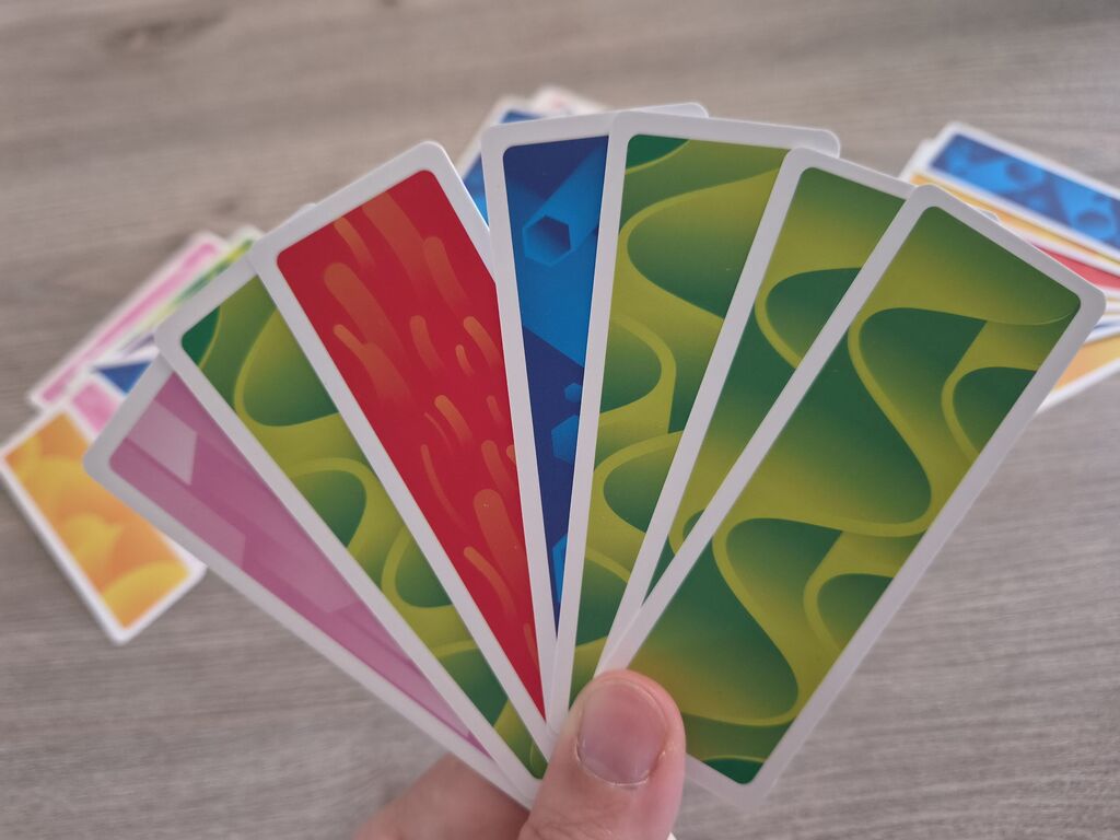 Hand hält bunte Karten.