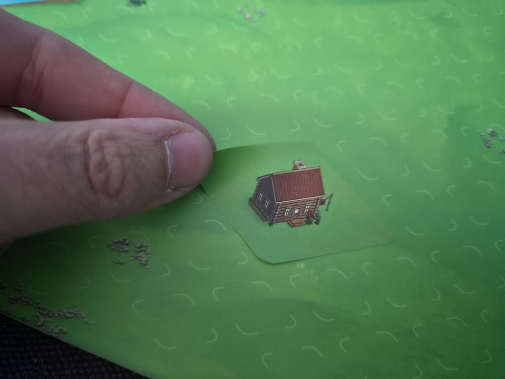 Hand klebt Aufkleber auf.