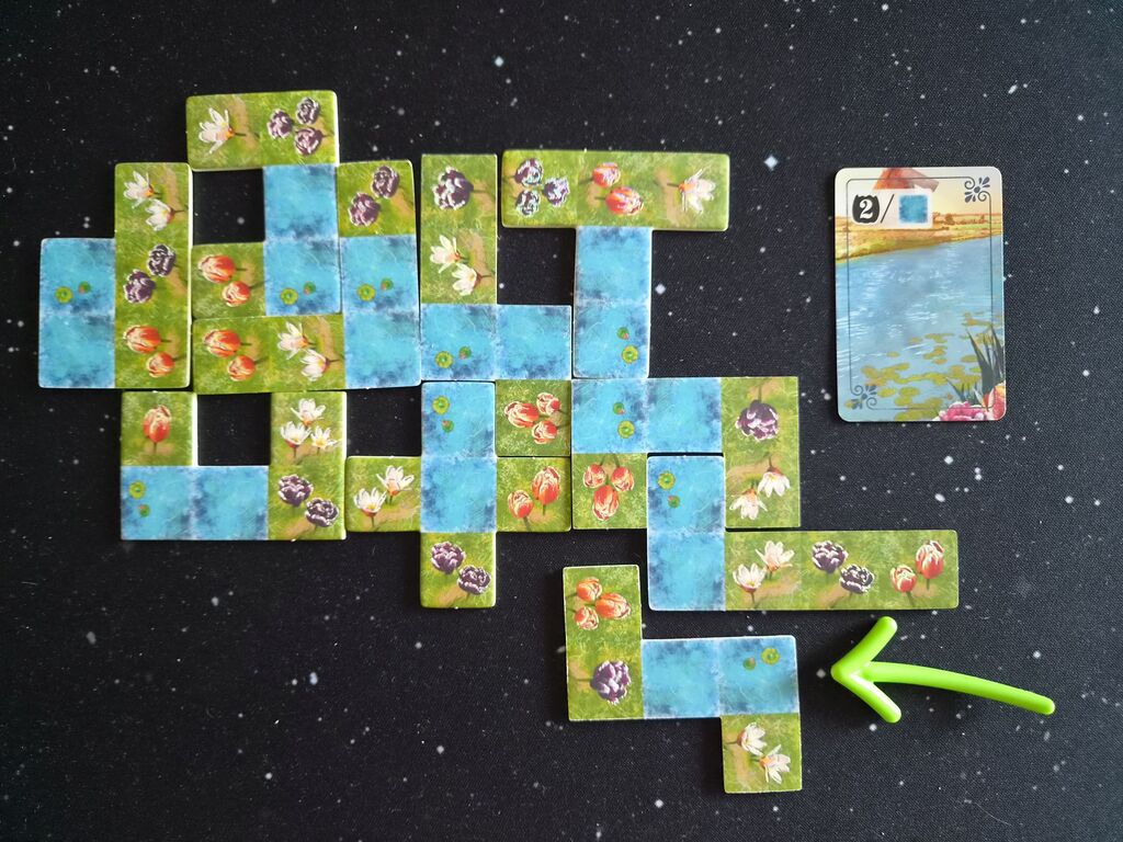 Spielmaterial mit Plättchen und einer Karte.