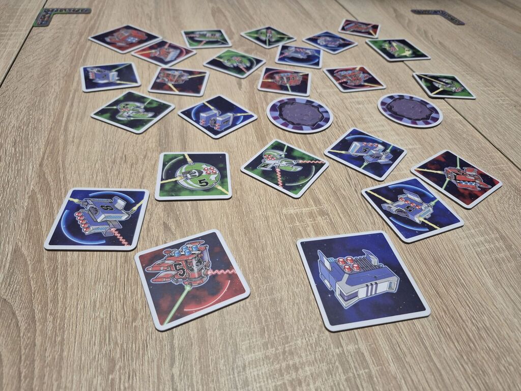 Plättchen aus "Light Speed Arena" auf einem Tisch.