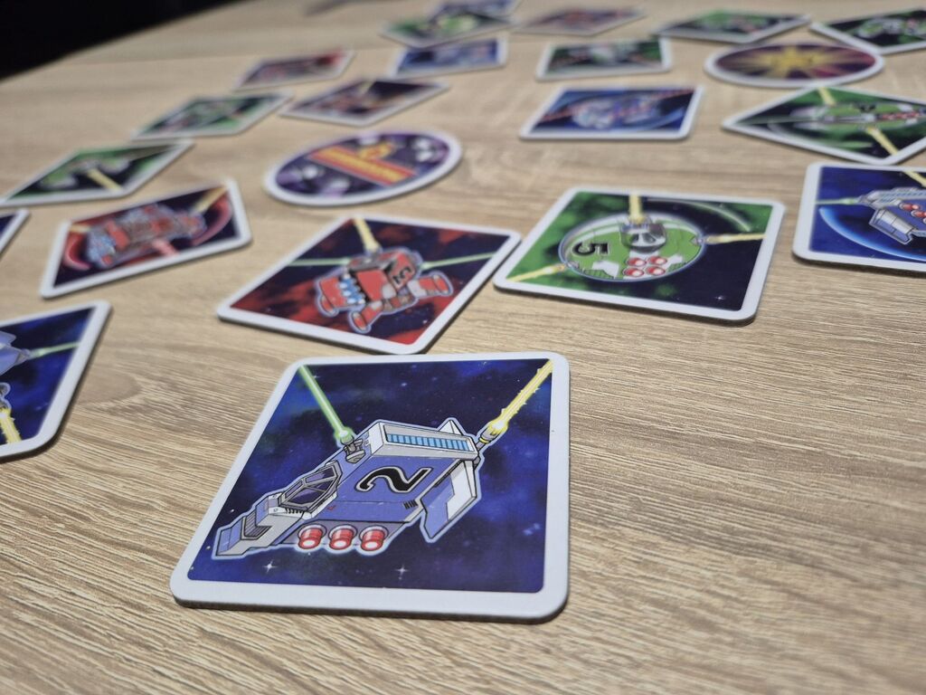 Plättchen aus "Light Speed Arena" auf einem Tisch.