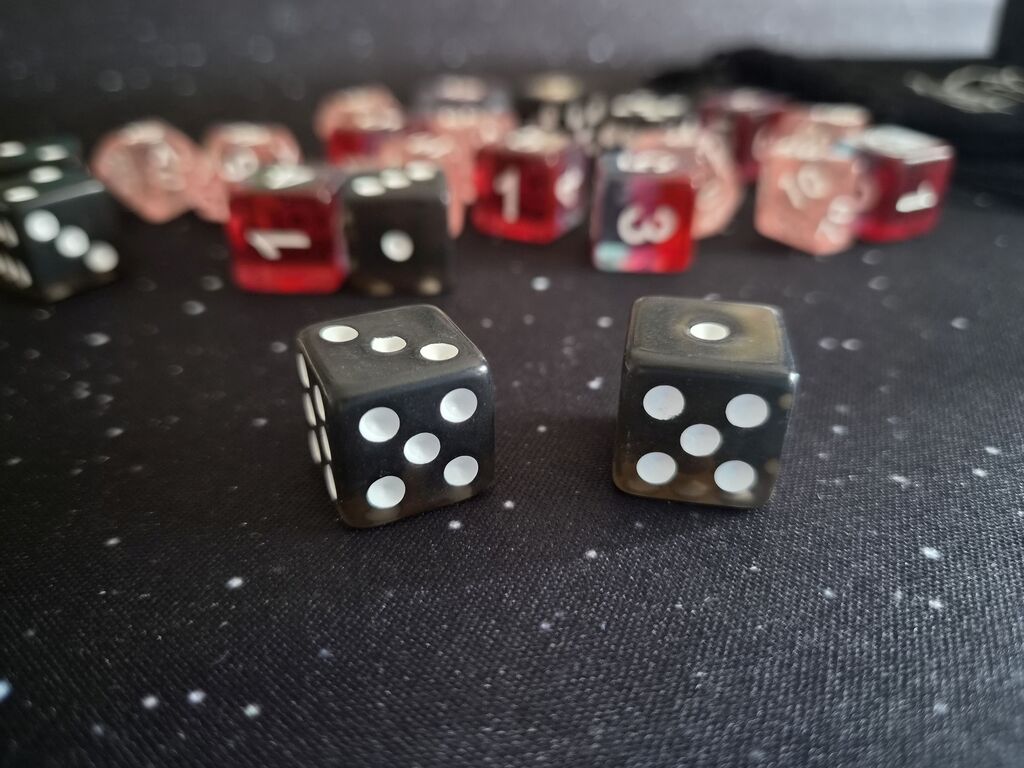 Zwei schwarze Würfel, dahinter weitere Würfel.