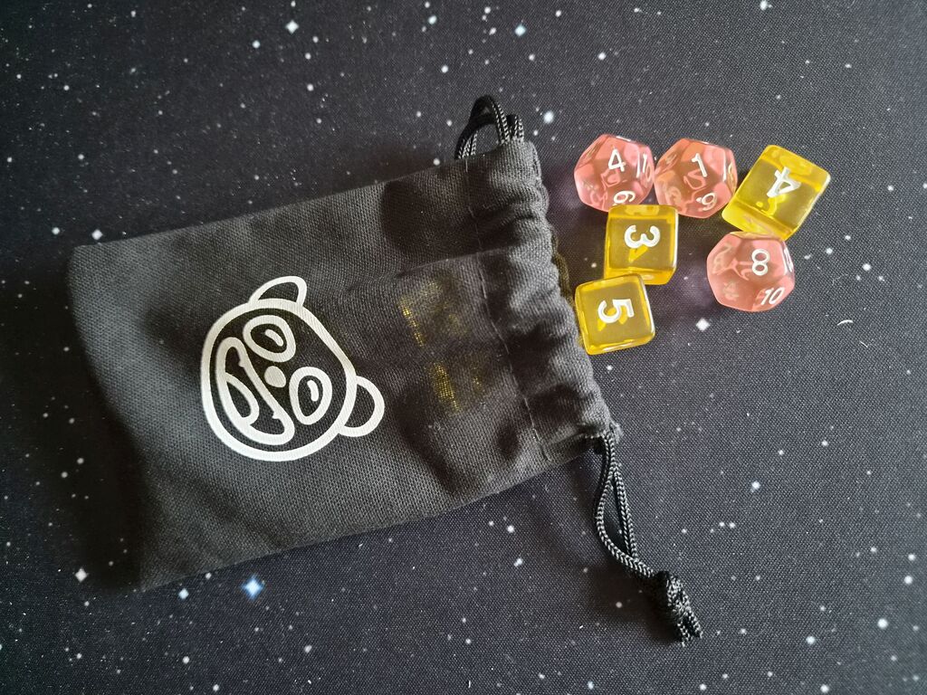 Schwarzer Beutel, daneben Würfel.