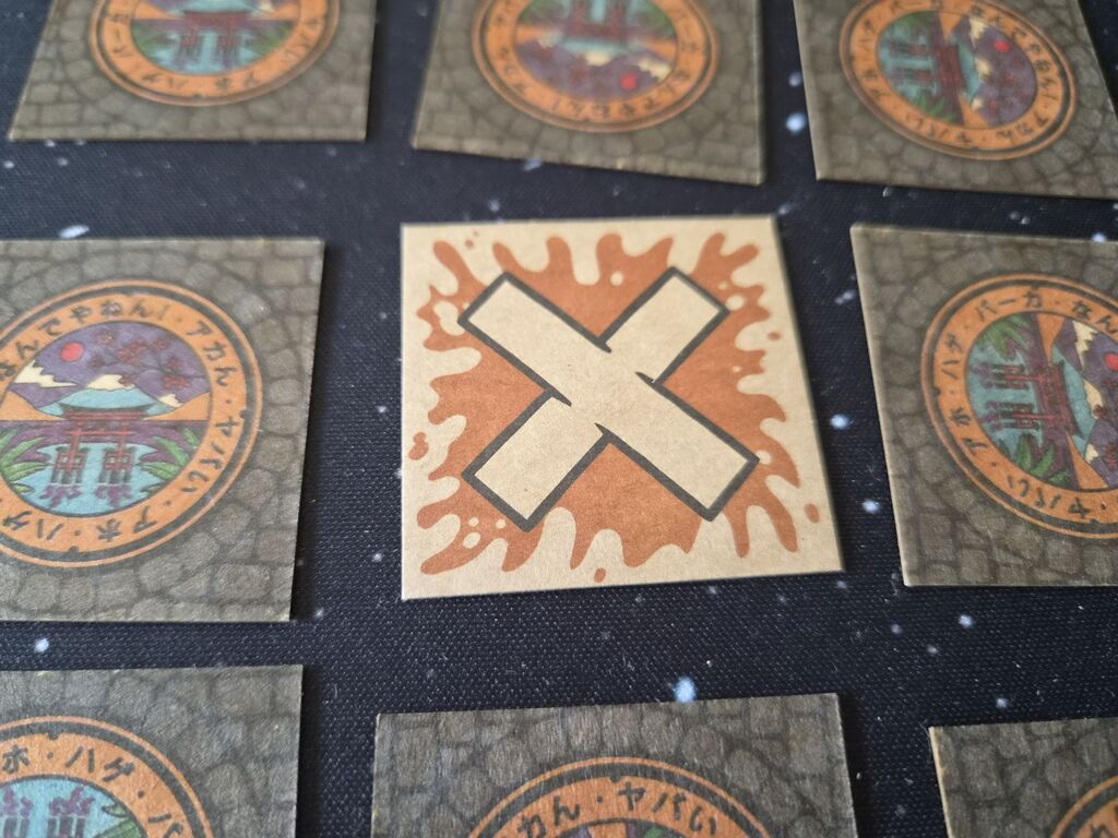 Ein aufgedecktes X-Plättchen.