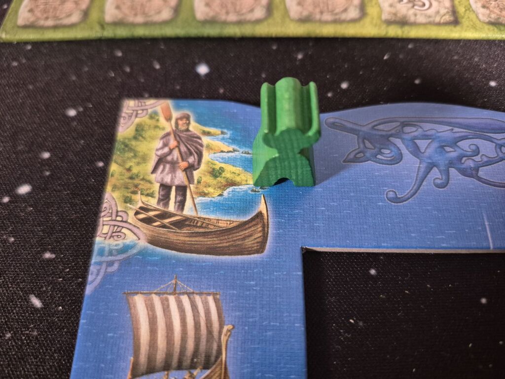Grüner Meeple auf Spielplanausschnitt.