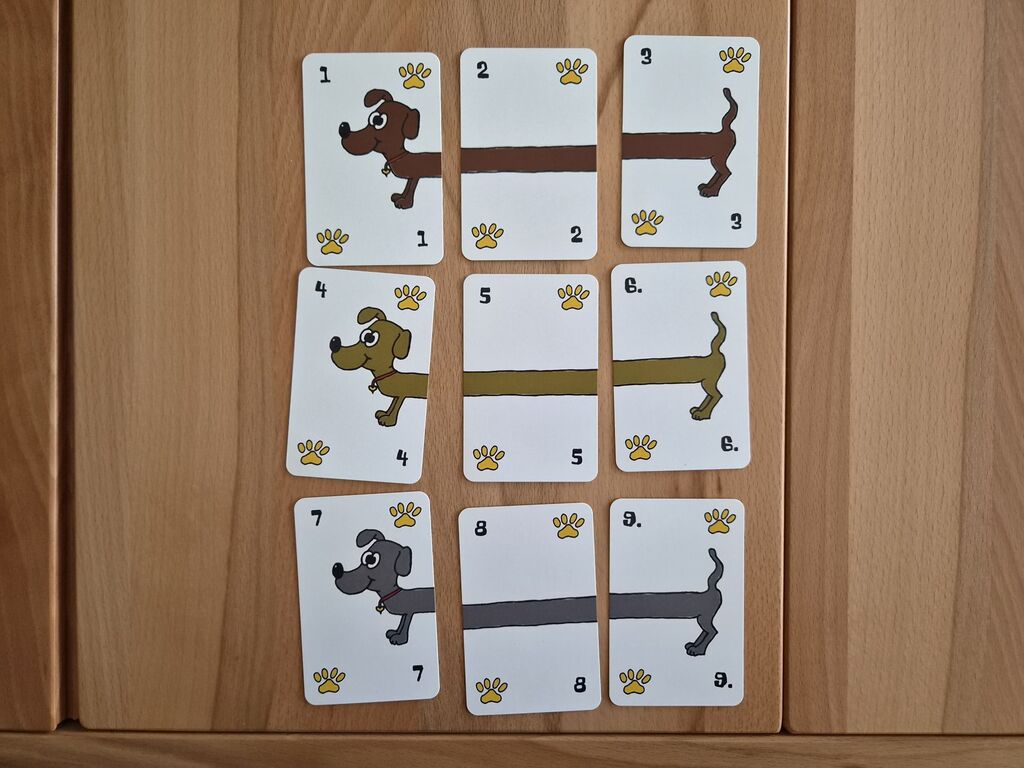 Neun Karten, die zusammengesetzt drei Dackel ergeben.