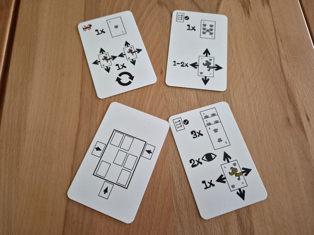 Vier Karten aus "Dackeln" mit Symbolen.