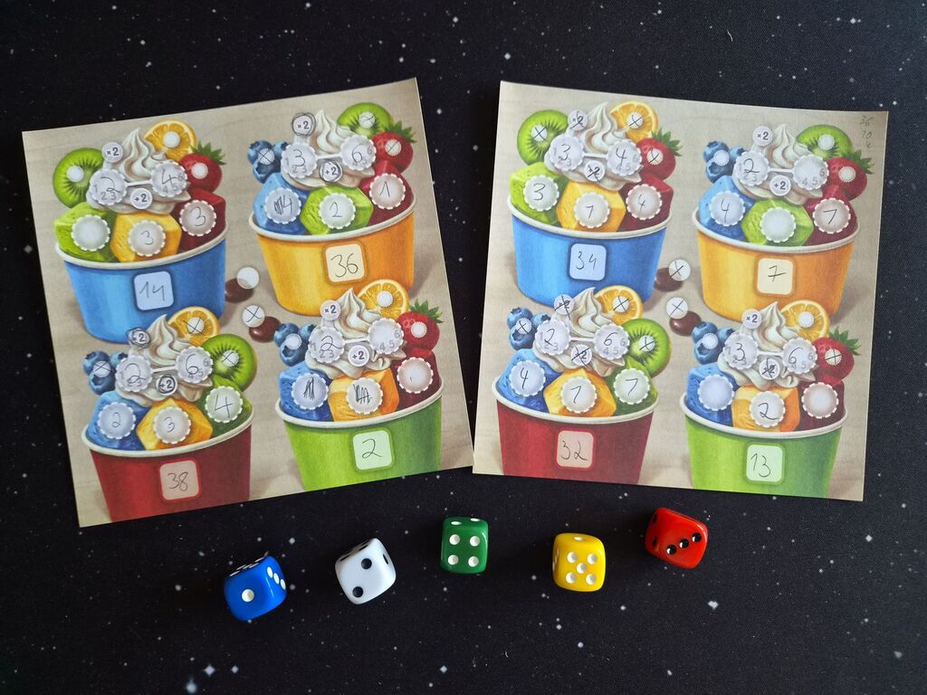 Zwei gefüllte Blätter vom Spielblock, darunter Würfel aus "Dicecream".