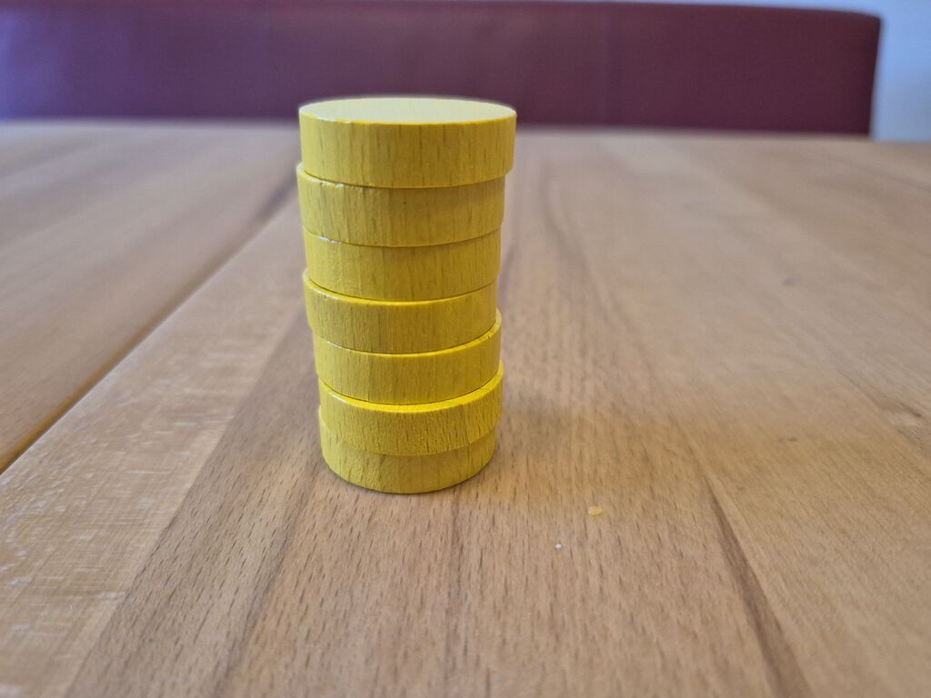 Ein Stapel runde, gelbe Holzscheiben.