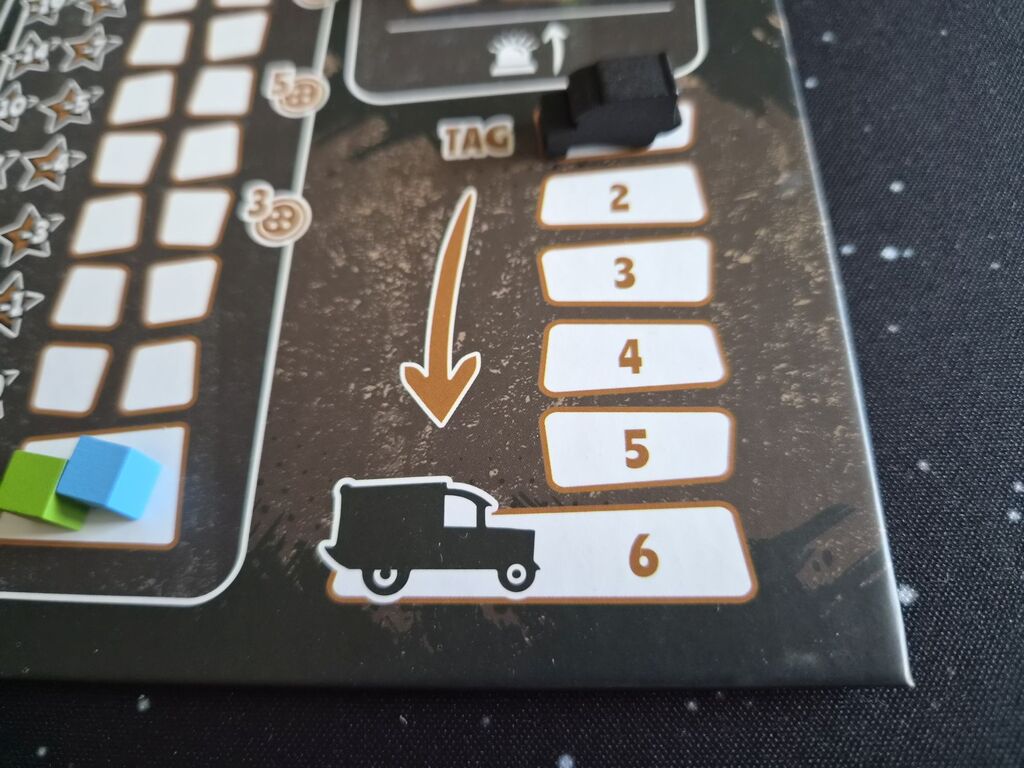 Müllautomarker steht auf oberem Feld einer Leiste auf dem Spielplan.