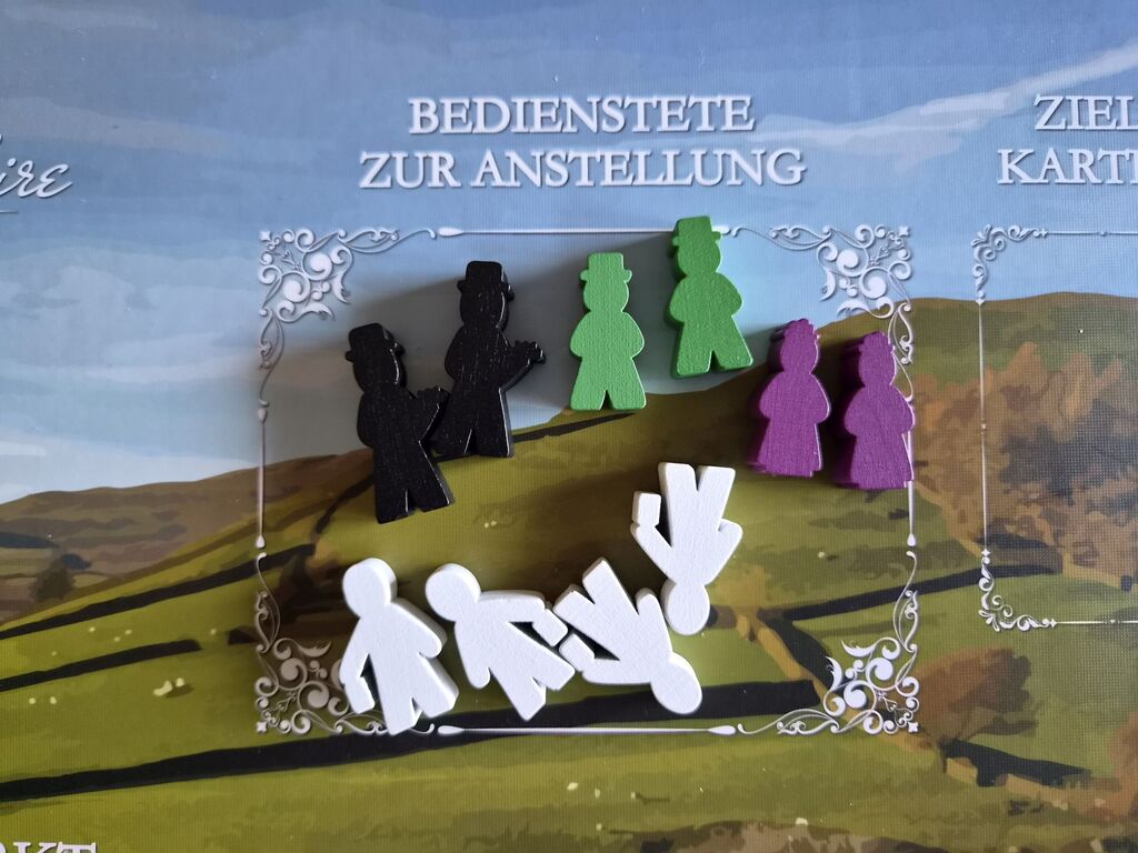 Spielfiguren mit unterschiedlicher Farbe und Form auf Spielplan.