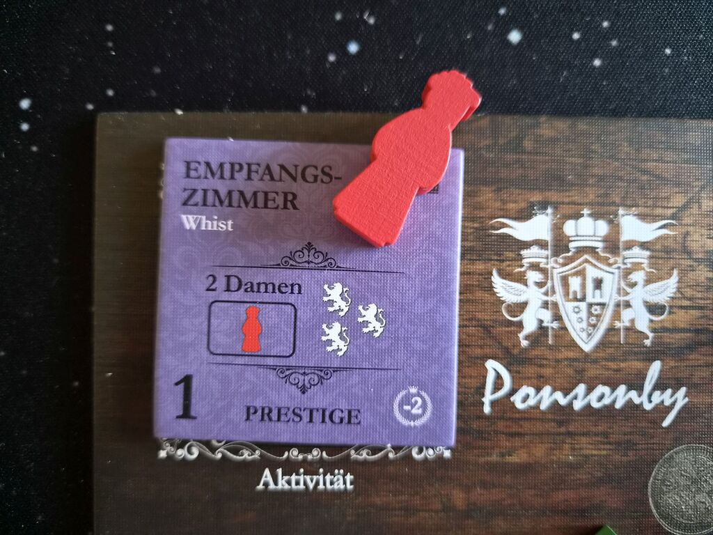 Rote Spielfigur auf Plättchen auf Spielertableau.