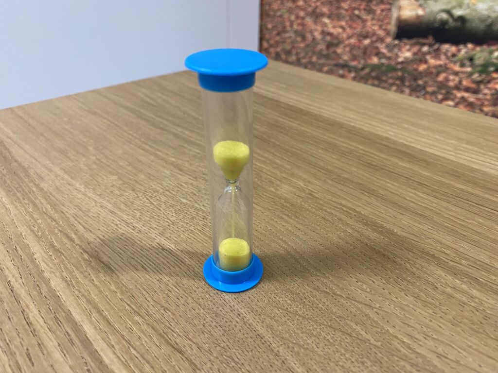 Blaue Sanduhr mit gelbem Sand.