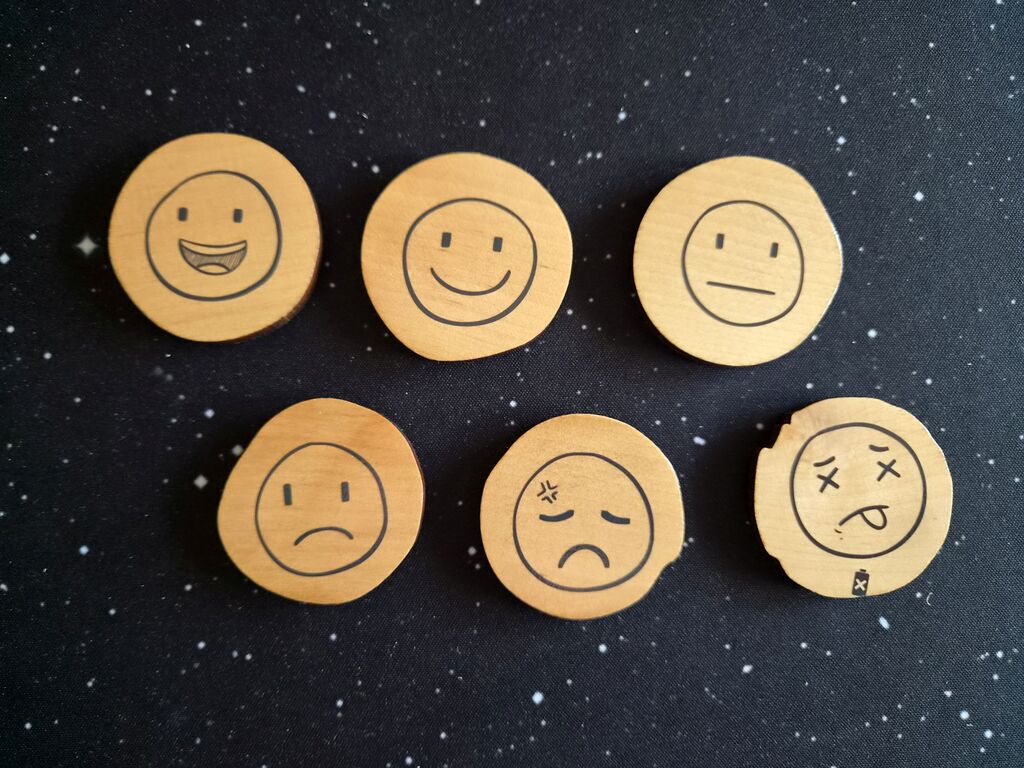 Holzscheiben mit unterschiedlichen Smileys.