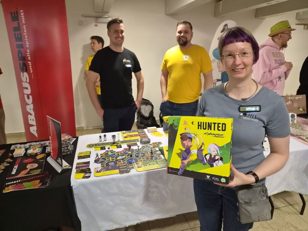 Frau hält Spiel vor Messestand.
