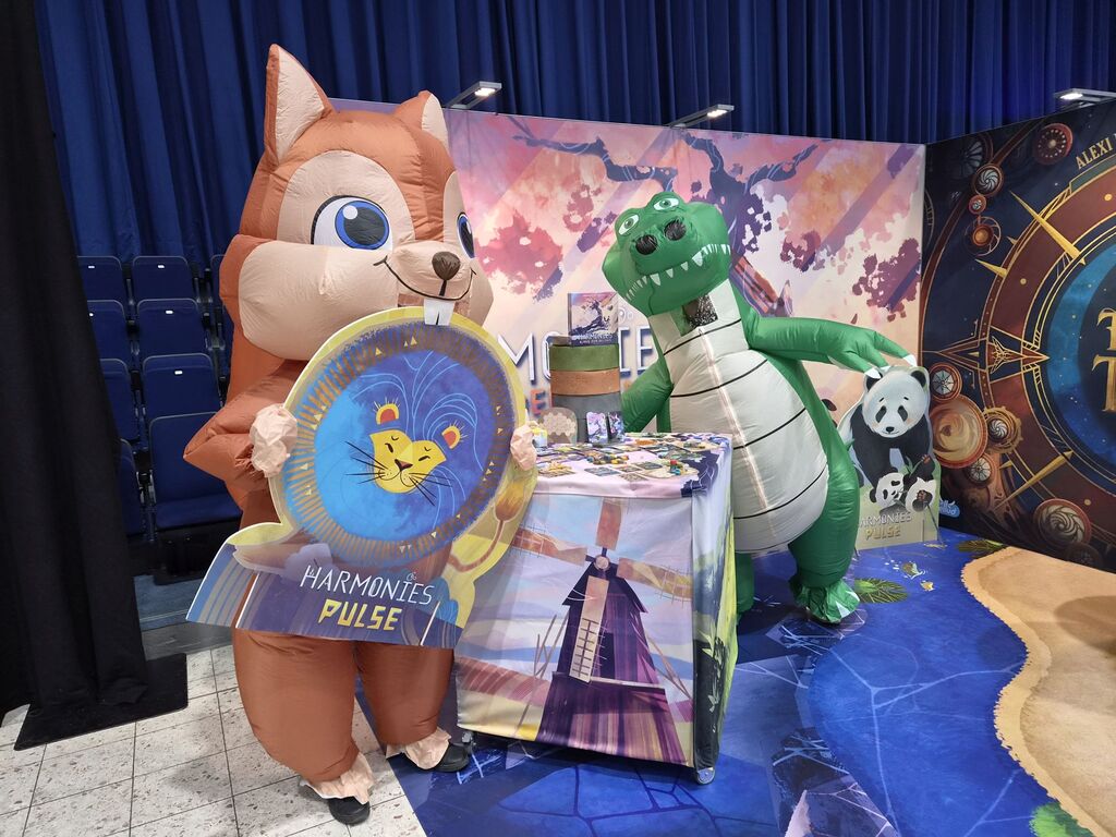 Mensch in Eichhörnchen und Mensch in Krokodilkostüm an Messestand.