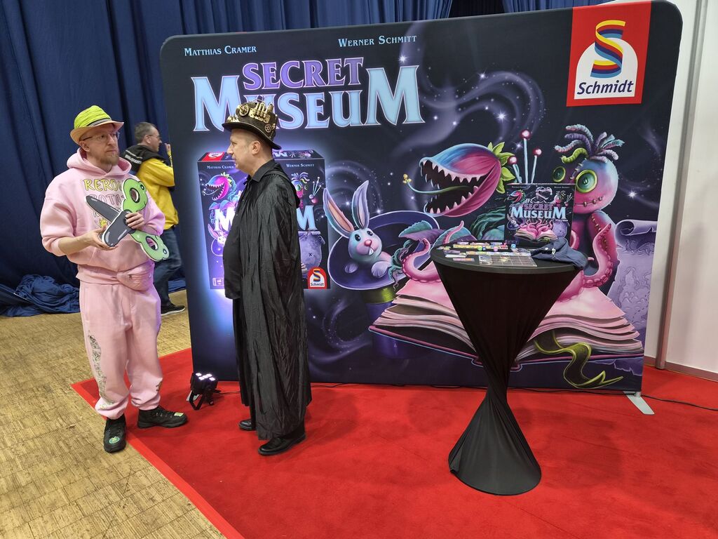 Messestand von "Secret Museum" mit zwei verkleideten Männern.