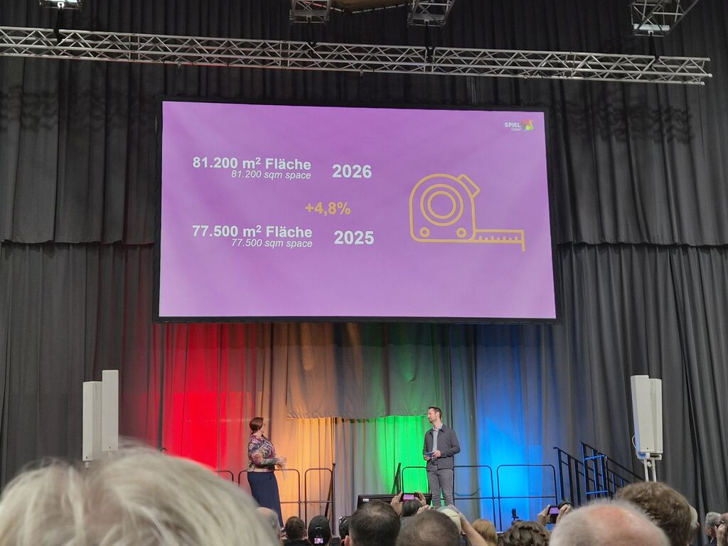 Präsentation auf großem Bildschirm mit Text und Zahlen bei der SPIEL 2026.